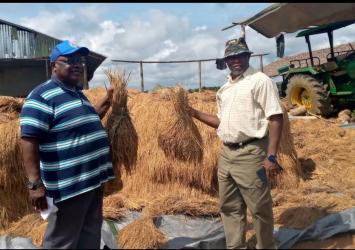 Acting Minister and Deputy Minister for Planning and Development Prof. Robert Fagans(R) with the farmer(L)